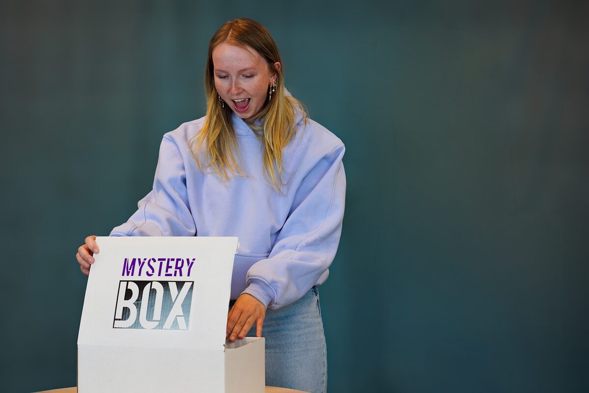 Frau öffnet überrascht eine Mystery Box